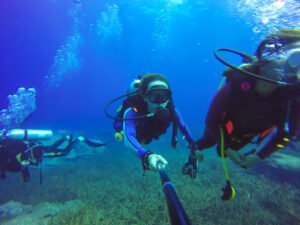 Underwater couple scuba diving selfie shot with selfie stick. De